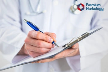 мужчина врач делает записи в журнале